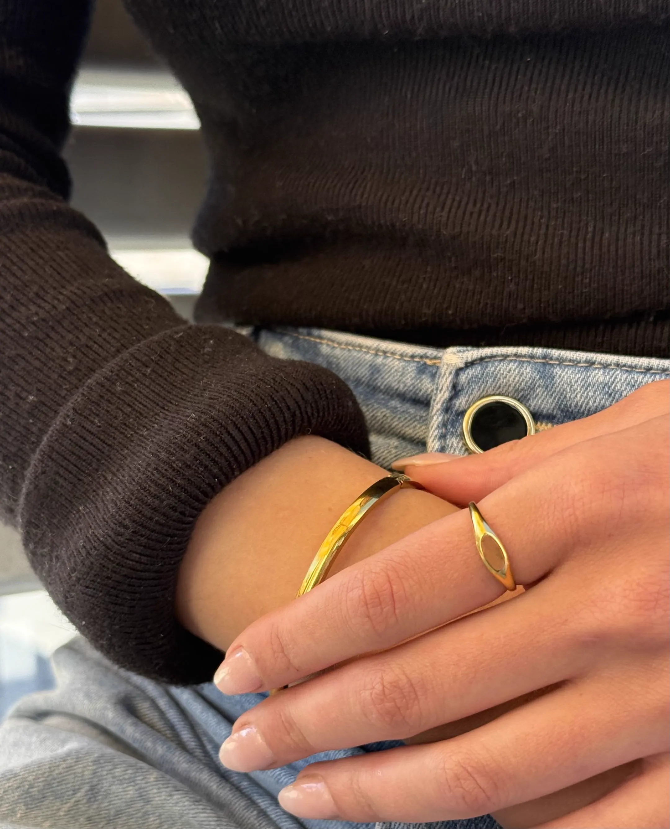 The Sole gold ring worn with the Mila bangle