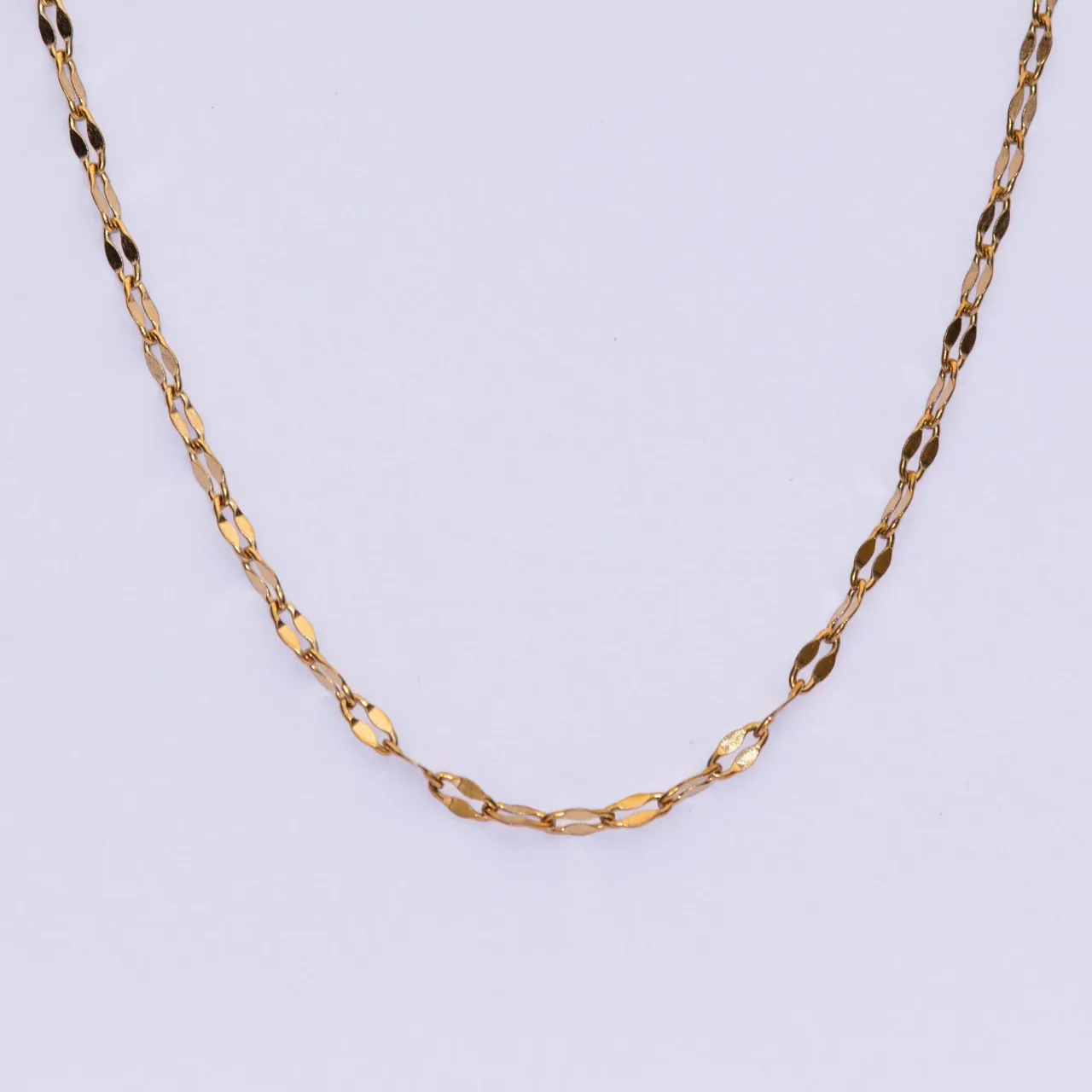 The Isa gold necklace — a flat faceted mariner chain