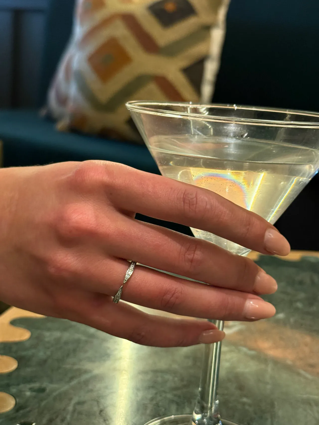 The Lune silver twisted pavé ring worn on a hand holding a martini glass